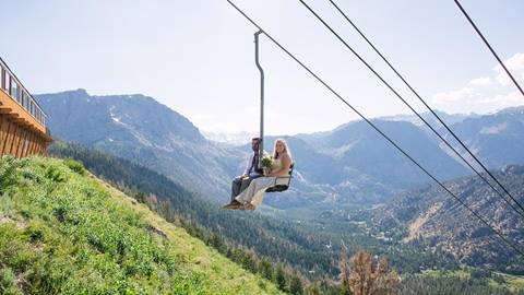 bride and groom riding up the chairlift at June