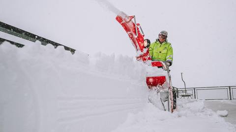 employee blowing snow on a powder day