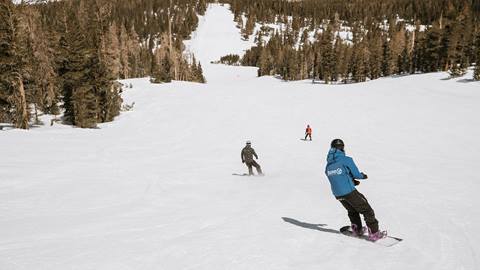 instructors and guests snowboarding