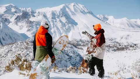 two snowboarders overlooking the terrain