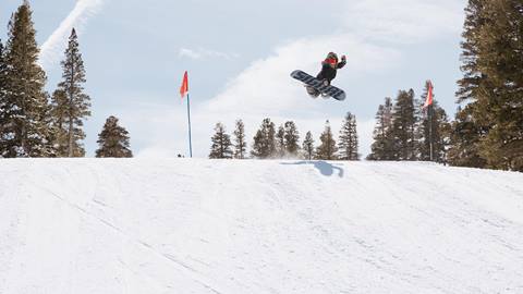 kid hitting a jump in terrain park